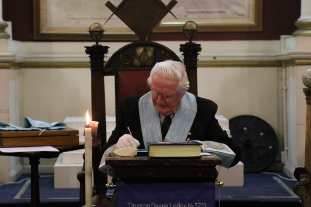 Image of the Worshipful Master making notes before a meeting